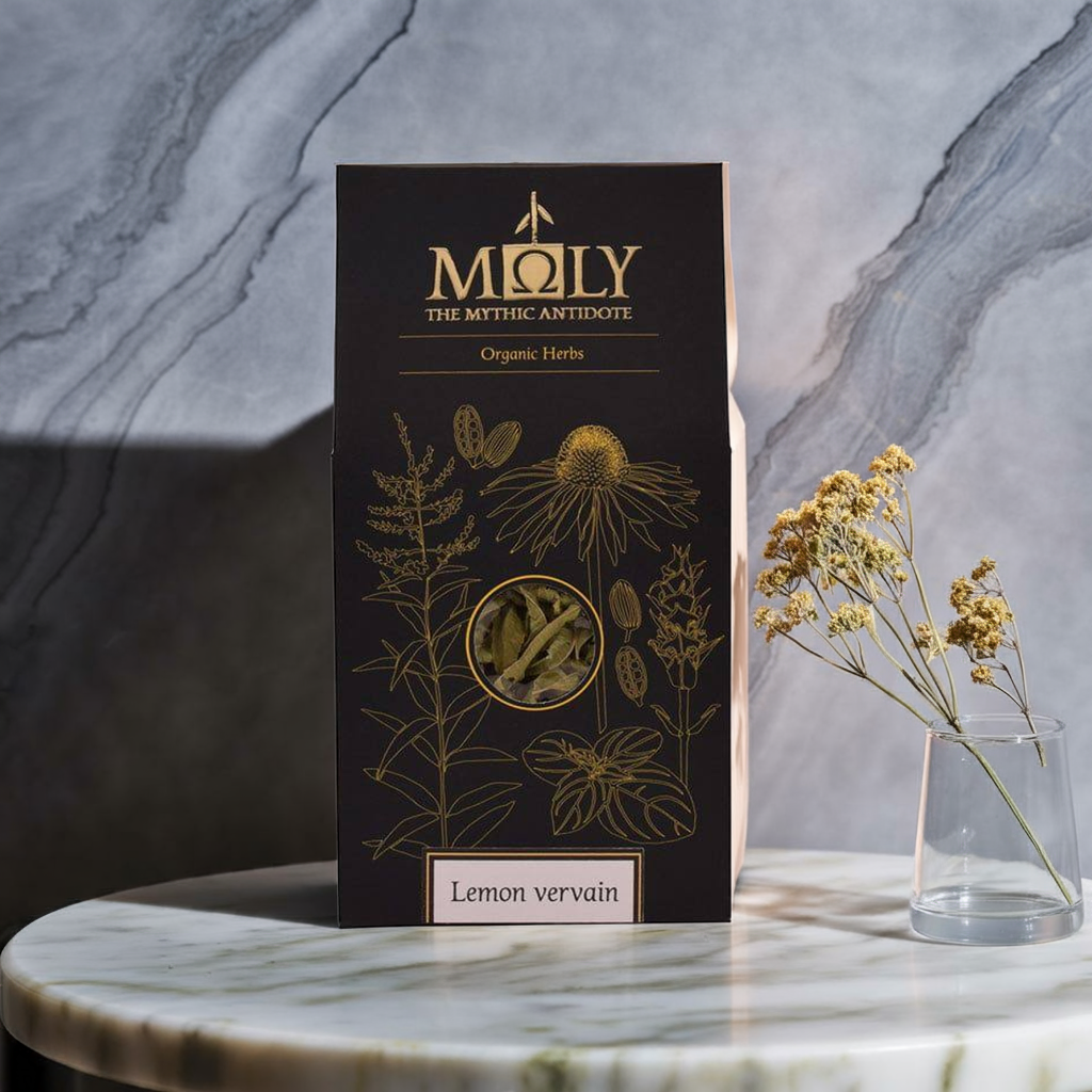 Eine schwarze Verpackung mit goldener Schrift & Pflanzen auf einem Marmortisch. Der Inhalt besteht aus 100% naturreiner Zitronenverbene.