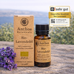 Kraftverpackung und Braunglasflasche mit ätherischem Lavendelöl bio 12 ml von Anthos Botanicals auf einem Felsen in der Natur.