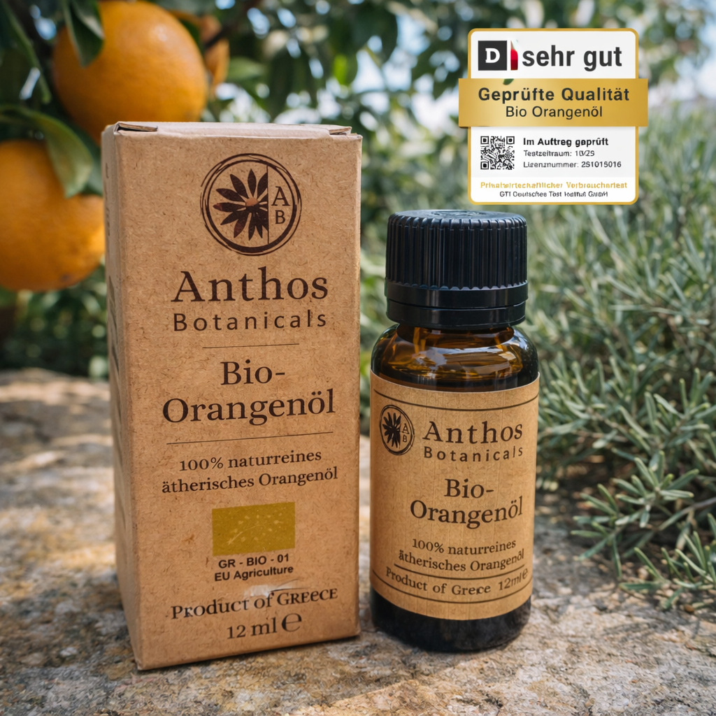 Kraftverpackung und Braunglasflasche mit ätherischem Orangenöl bio 12 ml von Anthos Botanicals auf einem Felsen in der Natur.