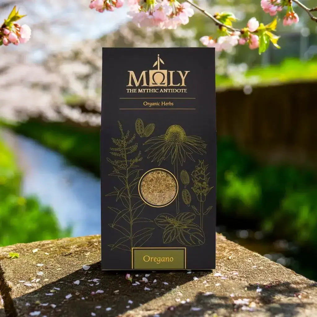 Eine Moly Verpackung mit Oregano bio auf einem Stein an einem Frühlingstag. Baumblüte im Hintergrund.