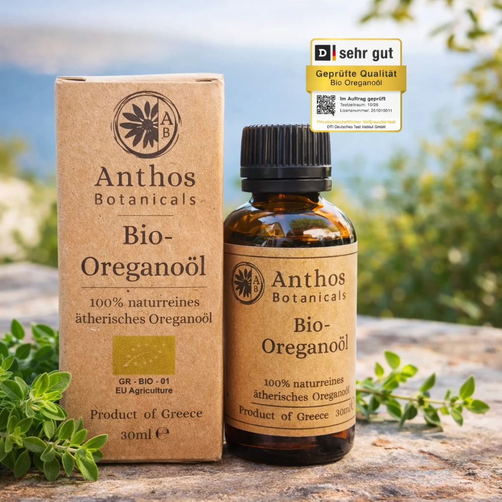 Kraftverpackung und Braunglasflasche mit ätherischem Oreganoöl bio von Anthos Botanicals auf einem Felsen mit Oreganopflanzen in einer mediterranen Landschaft.