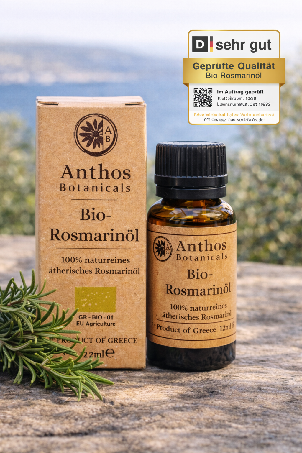 Kraftverpackung und Braunglasflasche des ätherischen Rosmarinöls bio von Anthos Botanicals auf einem Felsen in mediterraner Landschaft.