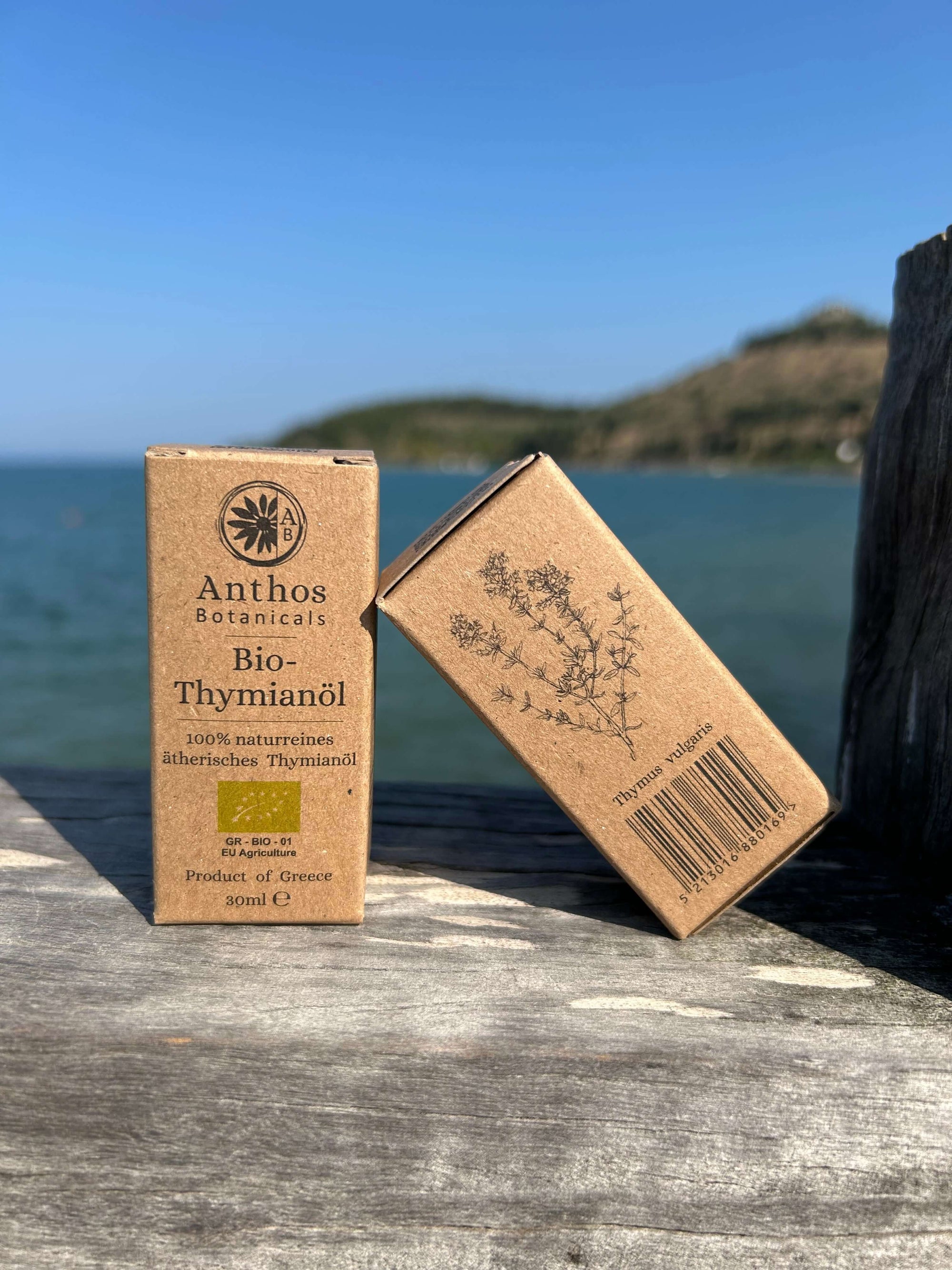 Zwei Kraftverpackungen mit Bio-Thymianöl auf einem Holzsteg.