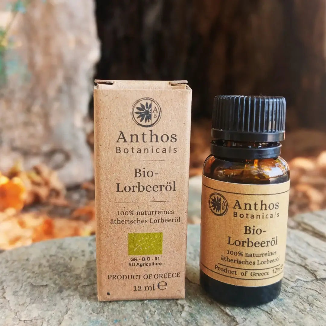 Ein braunes Glasfläschen mit Lorbeeröl & brauner Verpackung auf einem Felsen in der Natur.