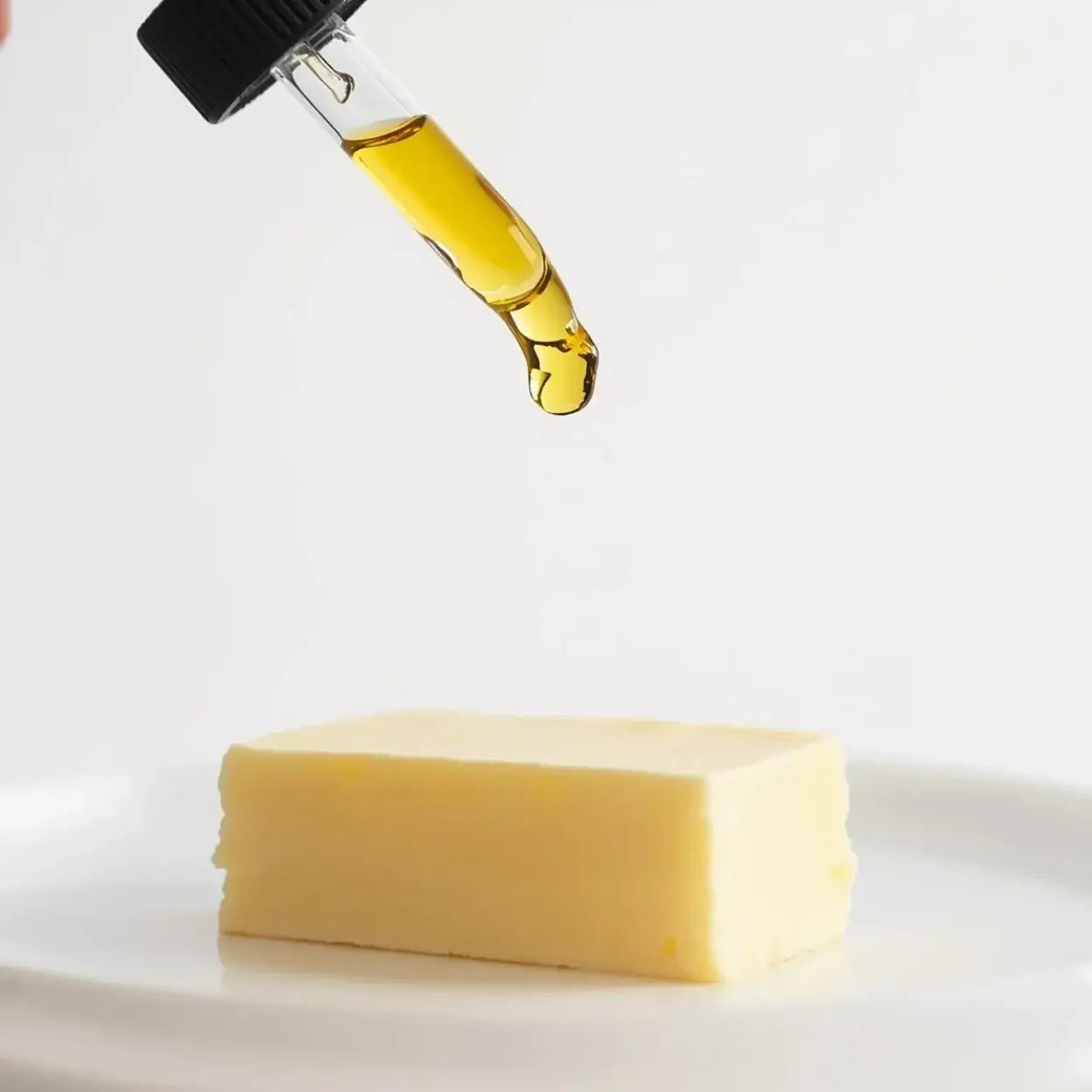 Ätherisches Öl wird auf ein Stück Butter geträufelt.