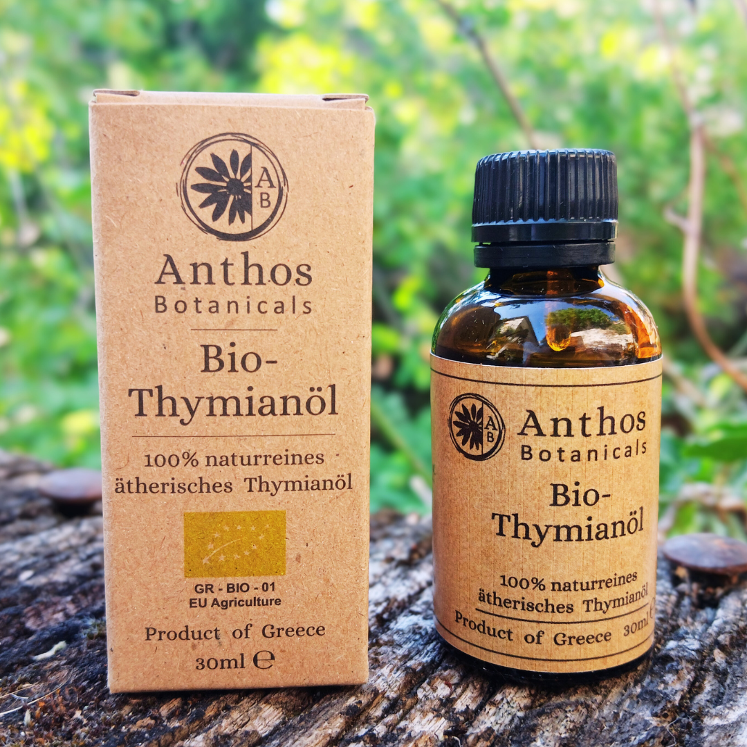 Kraftverpackung und Braunglasflasche mit Bio-Thymianöl auf einem Felsen in der Natur
