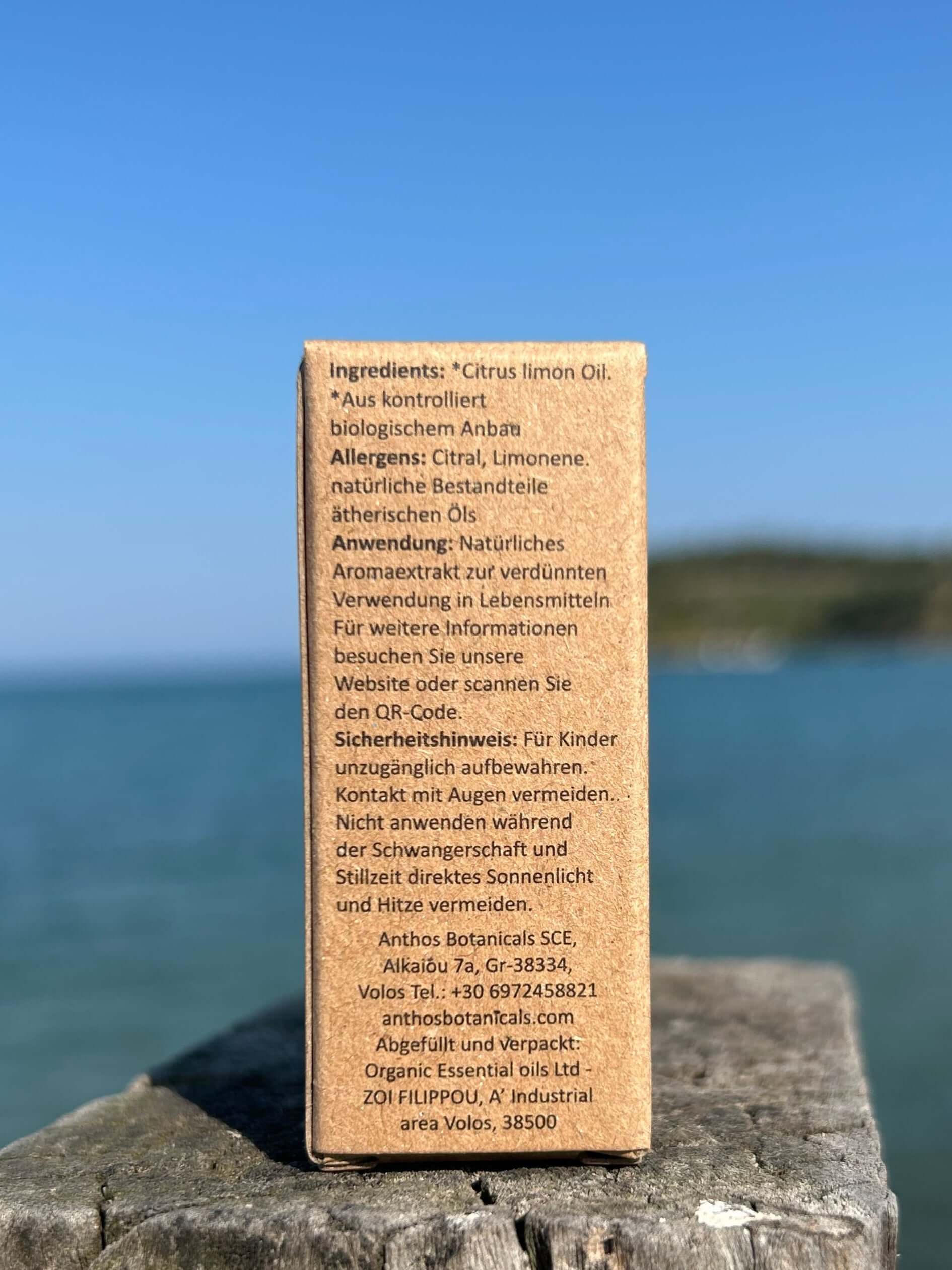 Eine Kraftverpackung mit ätherischem Bio-Zitronenöl auf einem Felsen am Meer.