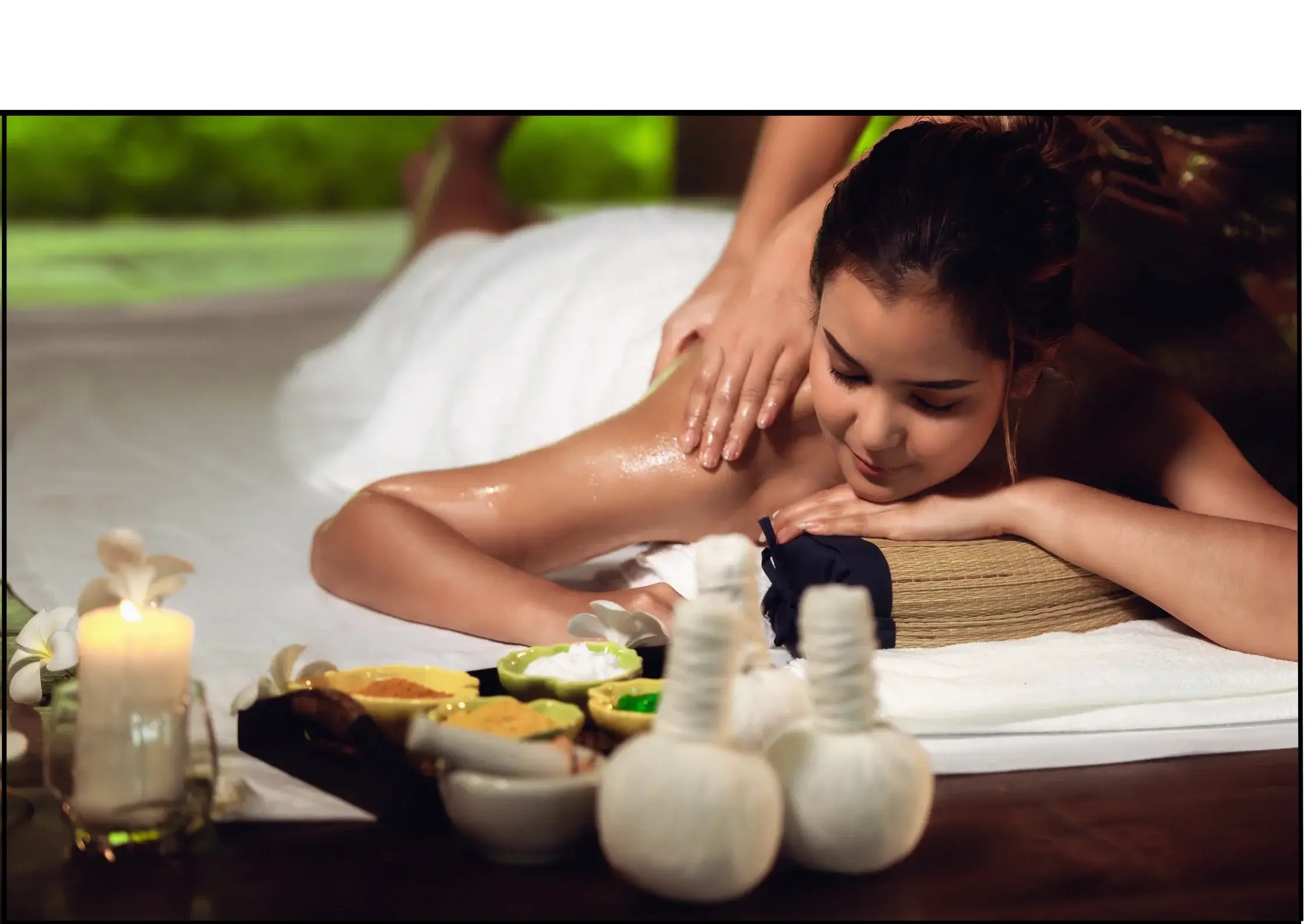 Eine junge Frau läßt sich in einem Spa massieren während einer Aromatherapie-Sitzung.