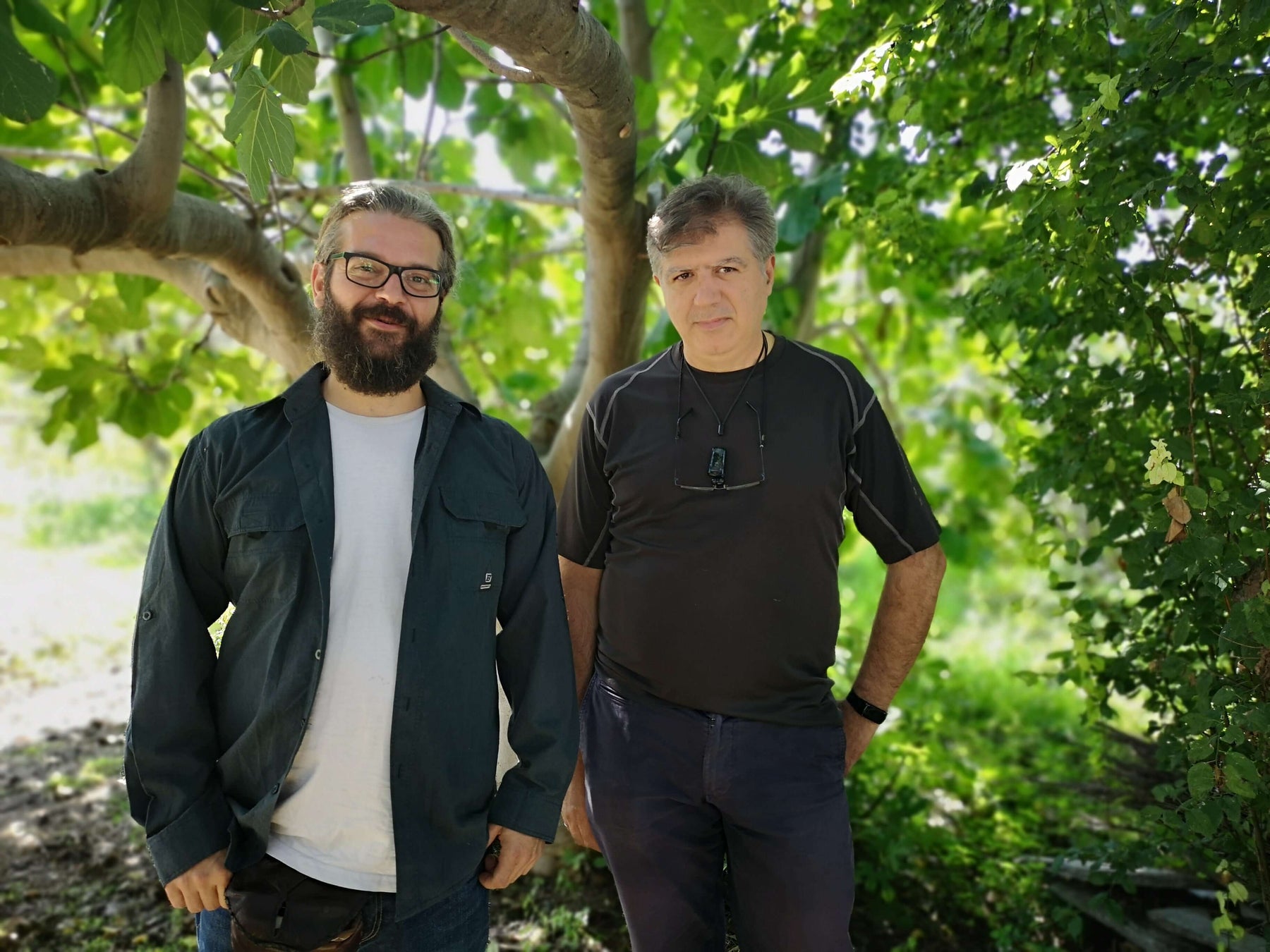 Dr. Christodoulos Vilaras und Manolis Manos stehen vor einem Baum.