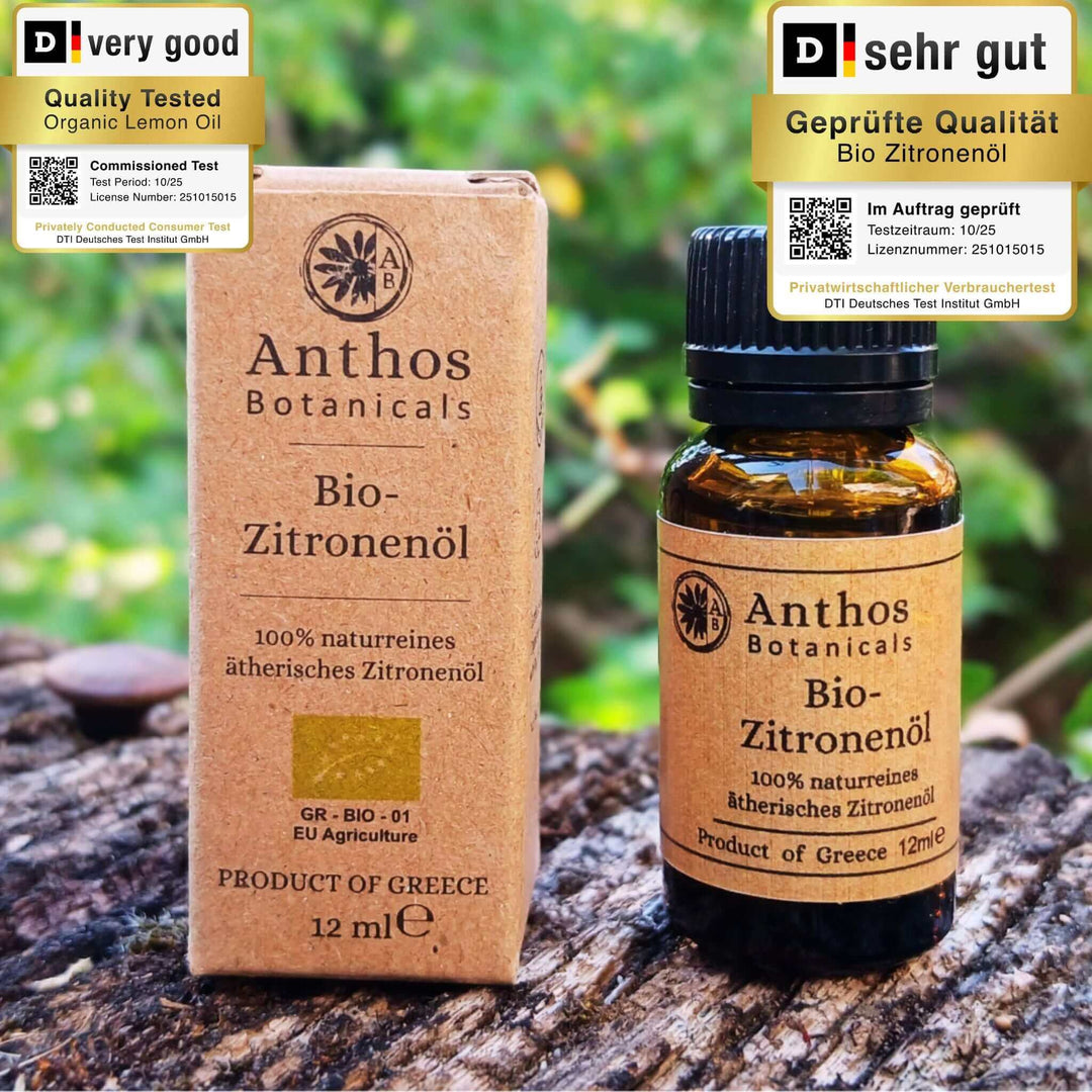 Braunglasflasche und Kraftverpackung mit biologischem Zitronenöl von Anthos Botanicals auf einem Felsen vor einem alten Baum.